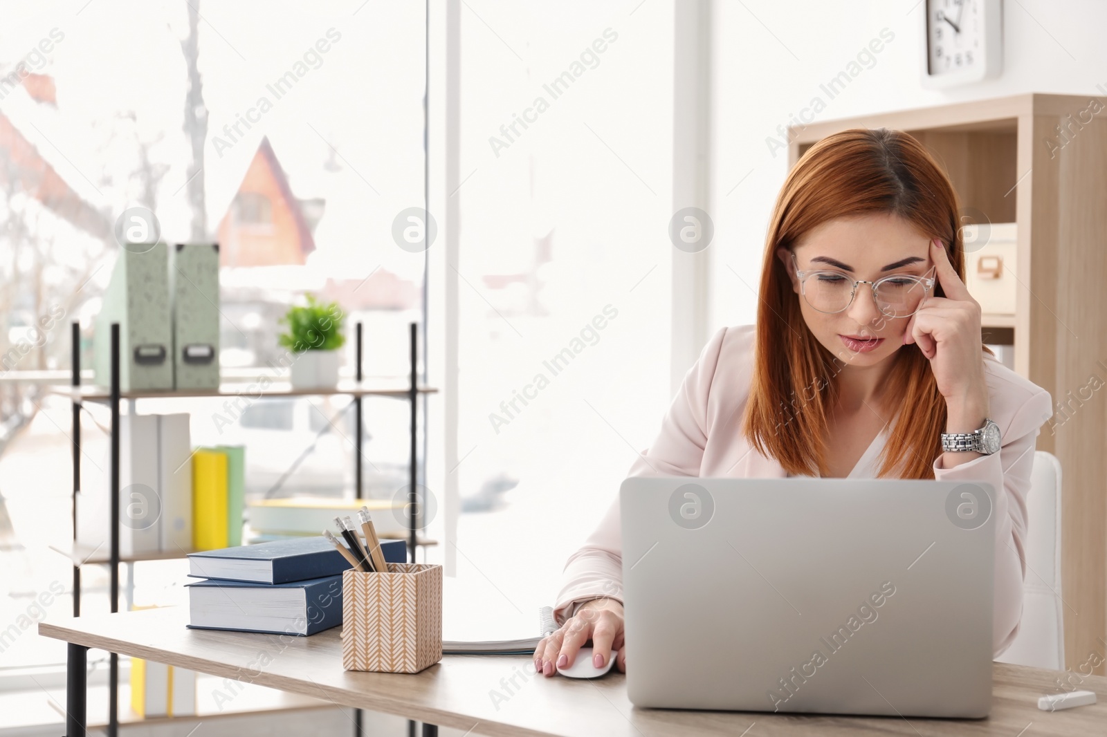 Photo of Beautiful young teacher with laptop sitting at table in classroom