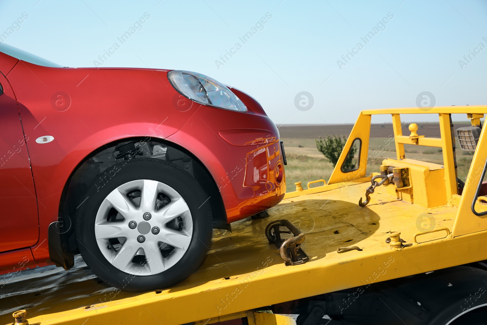 Photo of Tow truck with broken car outdoors on sunny day