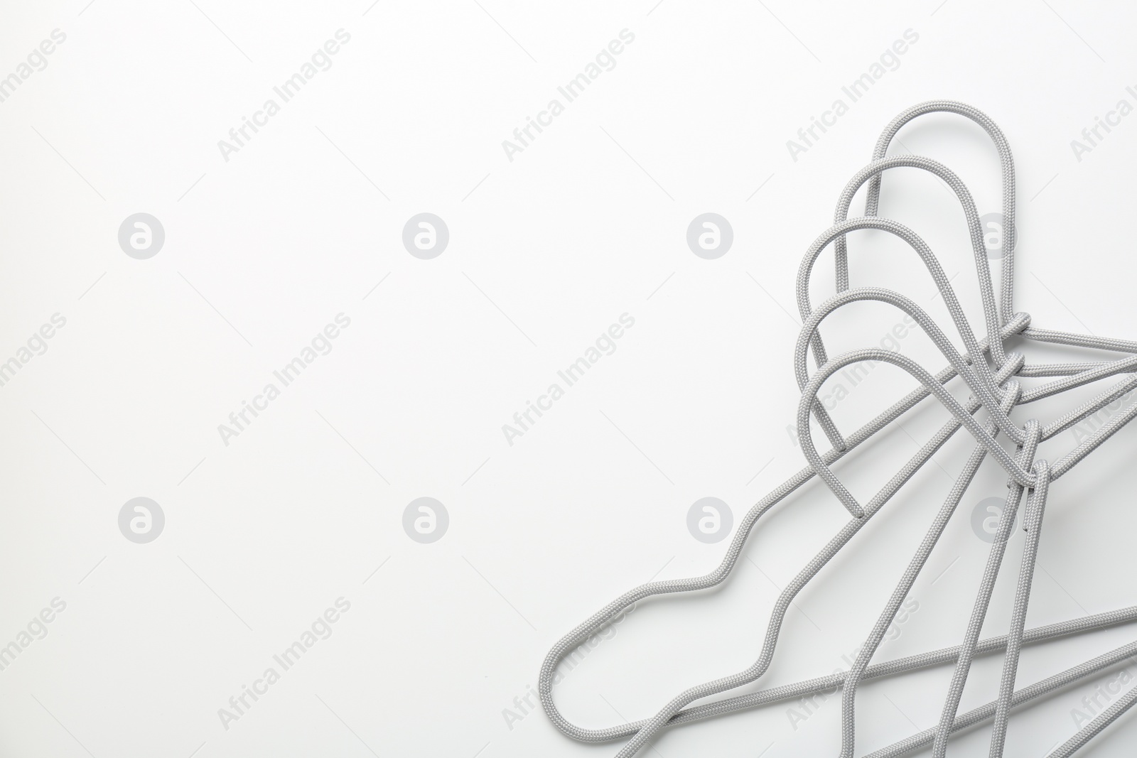 Photo of Hangers on white background, top view. Space for text