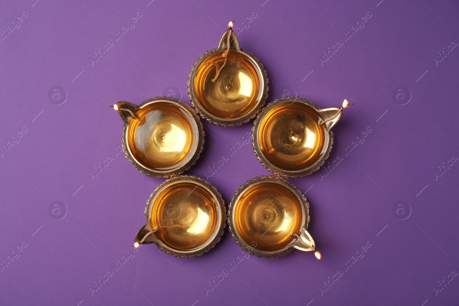 Photo of Diwali diyas or clay lamps on color background, top view