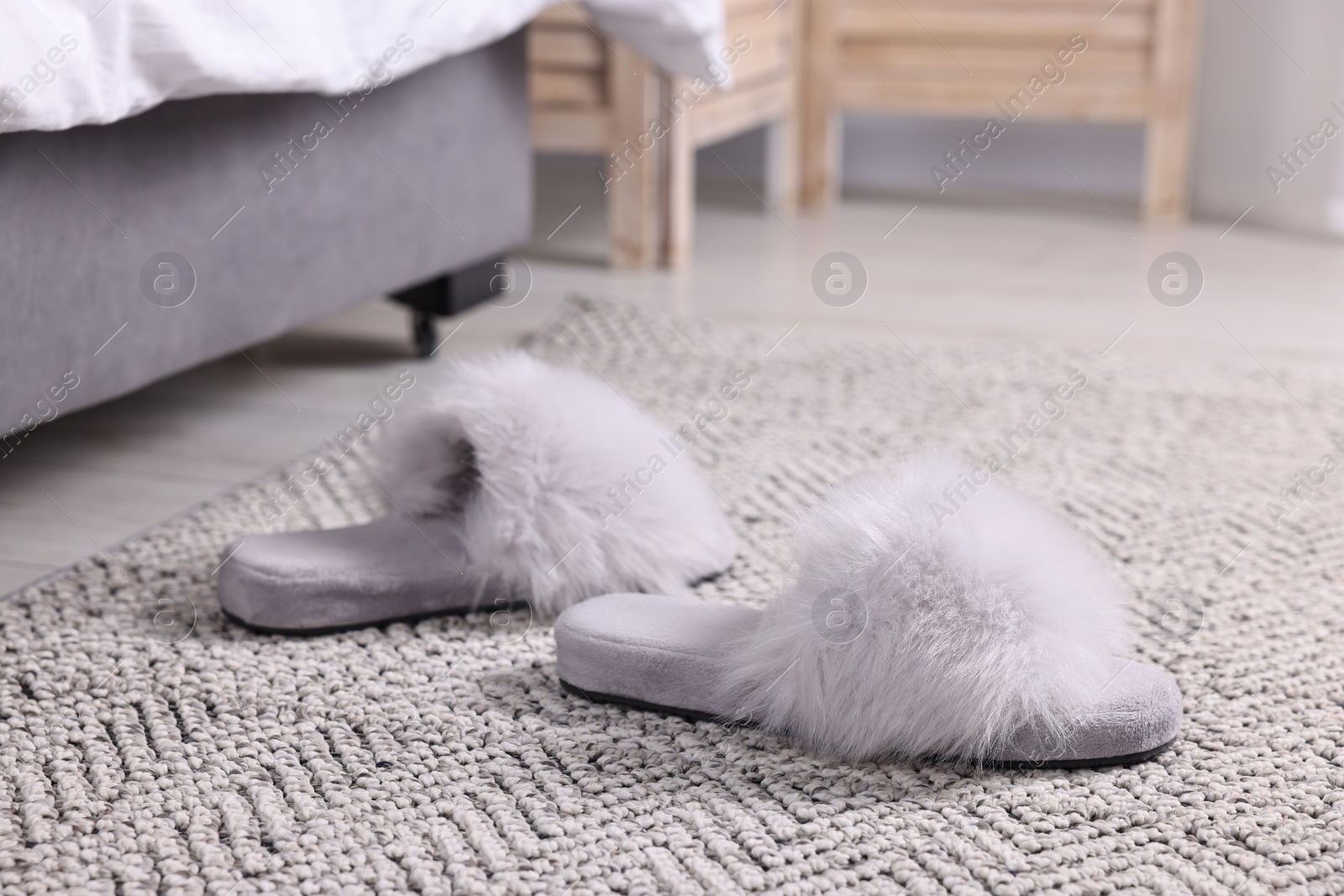 Photo of Grey soft slippers on carpet at home