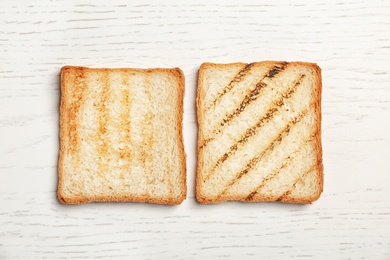 Toasted bread on light background, top view