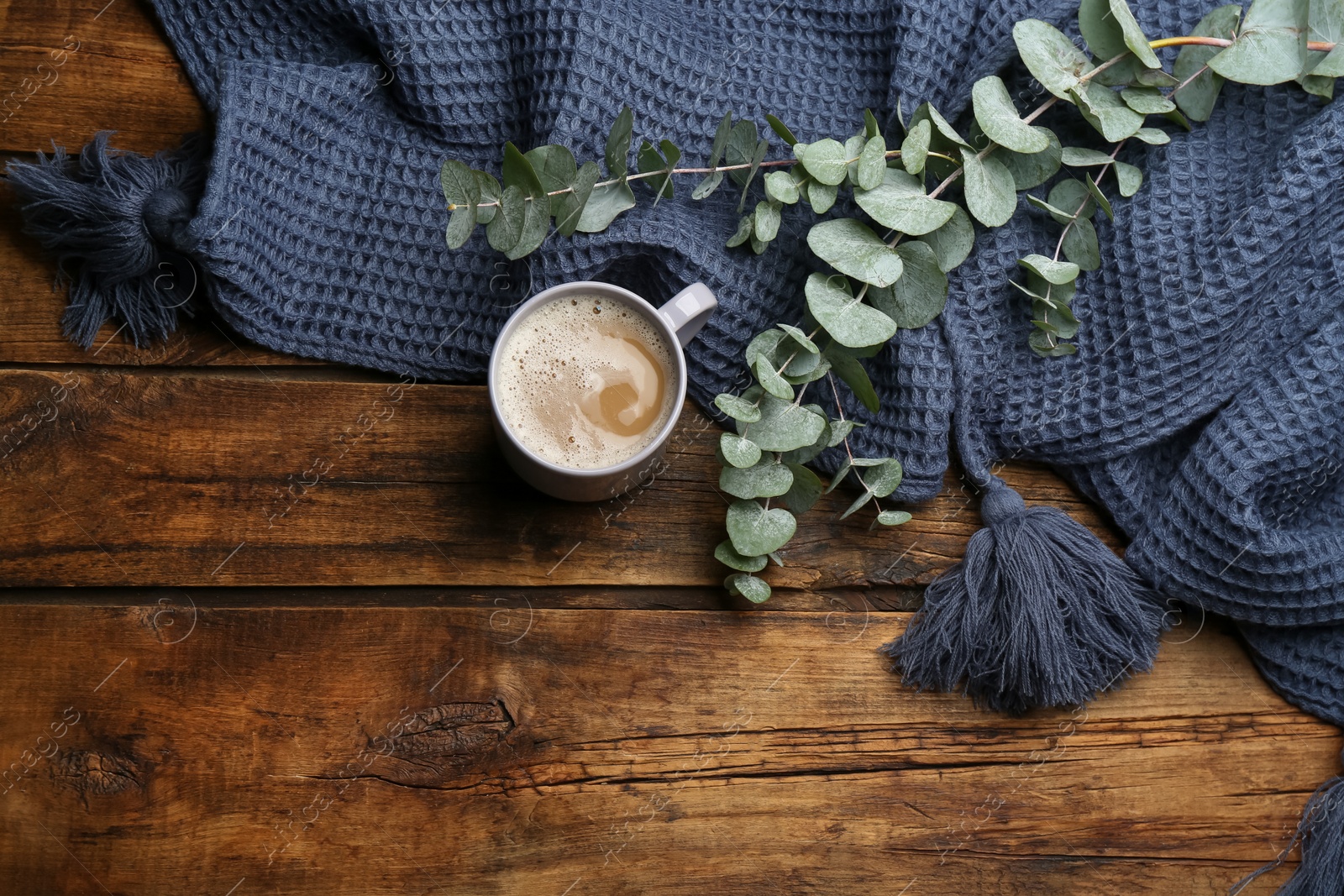 Photo of Flat lay composition with coffee and warm plaid on wooden table, space for text