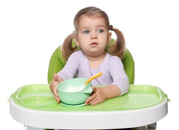 Photo of Cute little child with bowl of tasty yogurt in high chair on white background