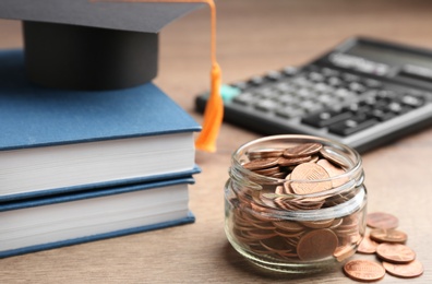 Photo of Composition with jar of coins on wooden table. Money saving concept