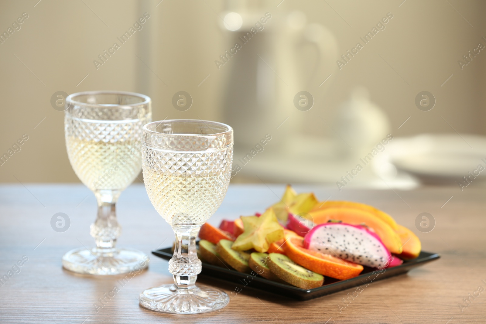 Photo of Delicious exotic fruits and wine on wooden table