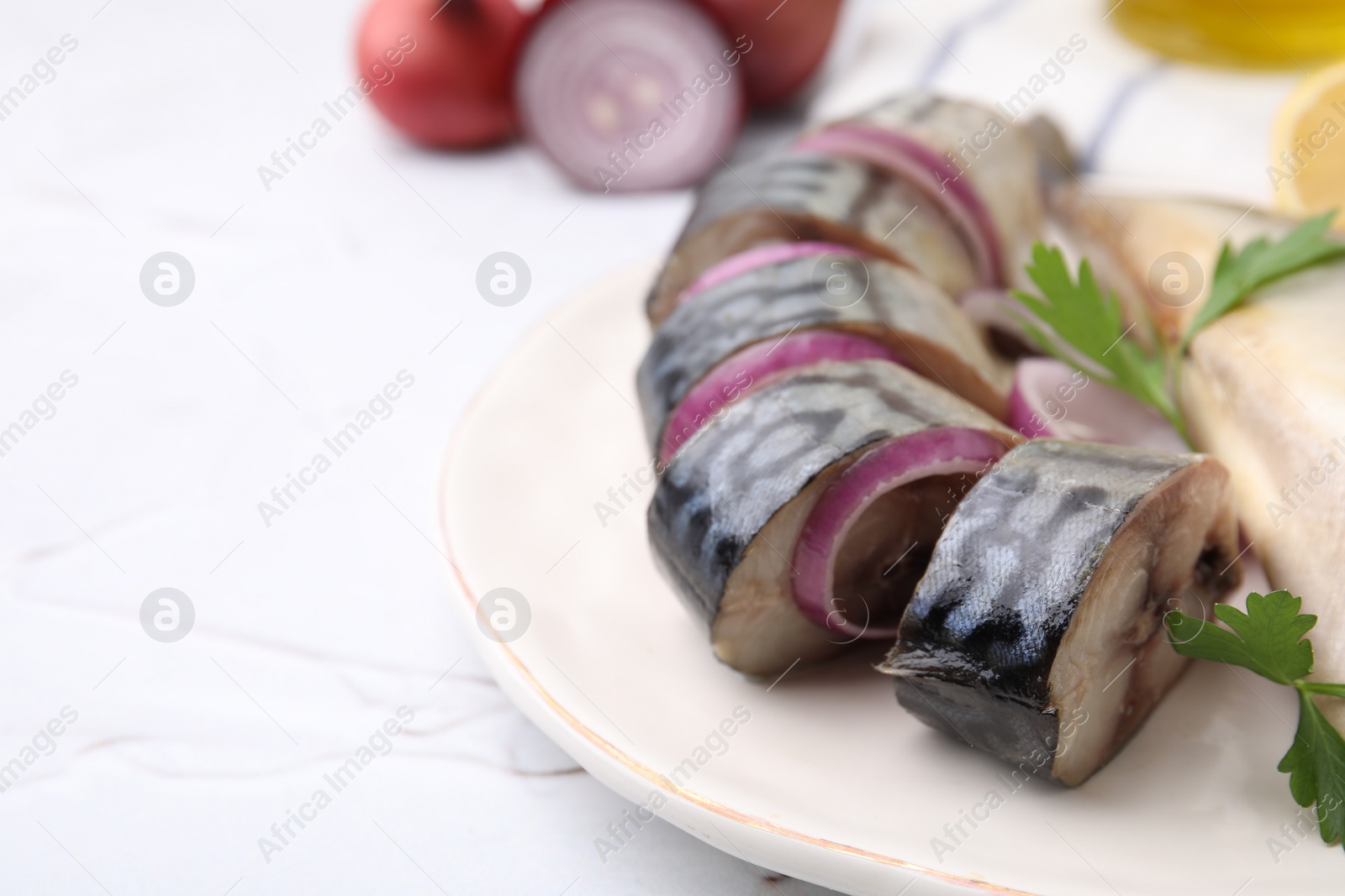 Photo of Tasty salted mackerel, parsley and onion on white textured table, closeup. Space for text