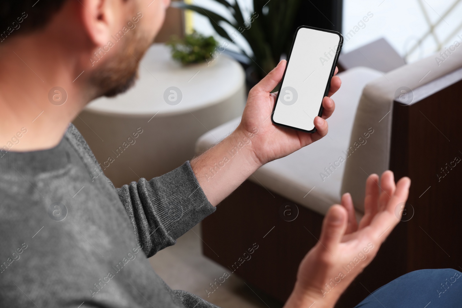 Photo of Man using smartphone in cafe, closeup view