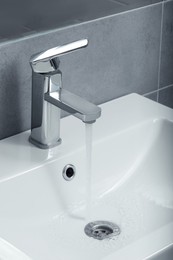 Stream of water flowing from tap in bathroom