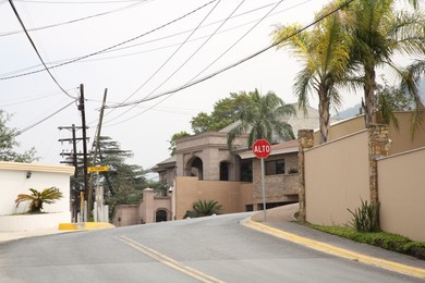 Photo of San Pedro Garza Garcia, Mexico – March 20, 2023: View of city street with road, beautiful houses and green palms
