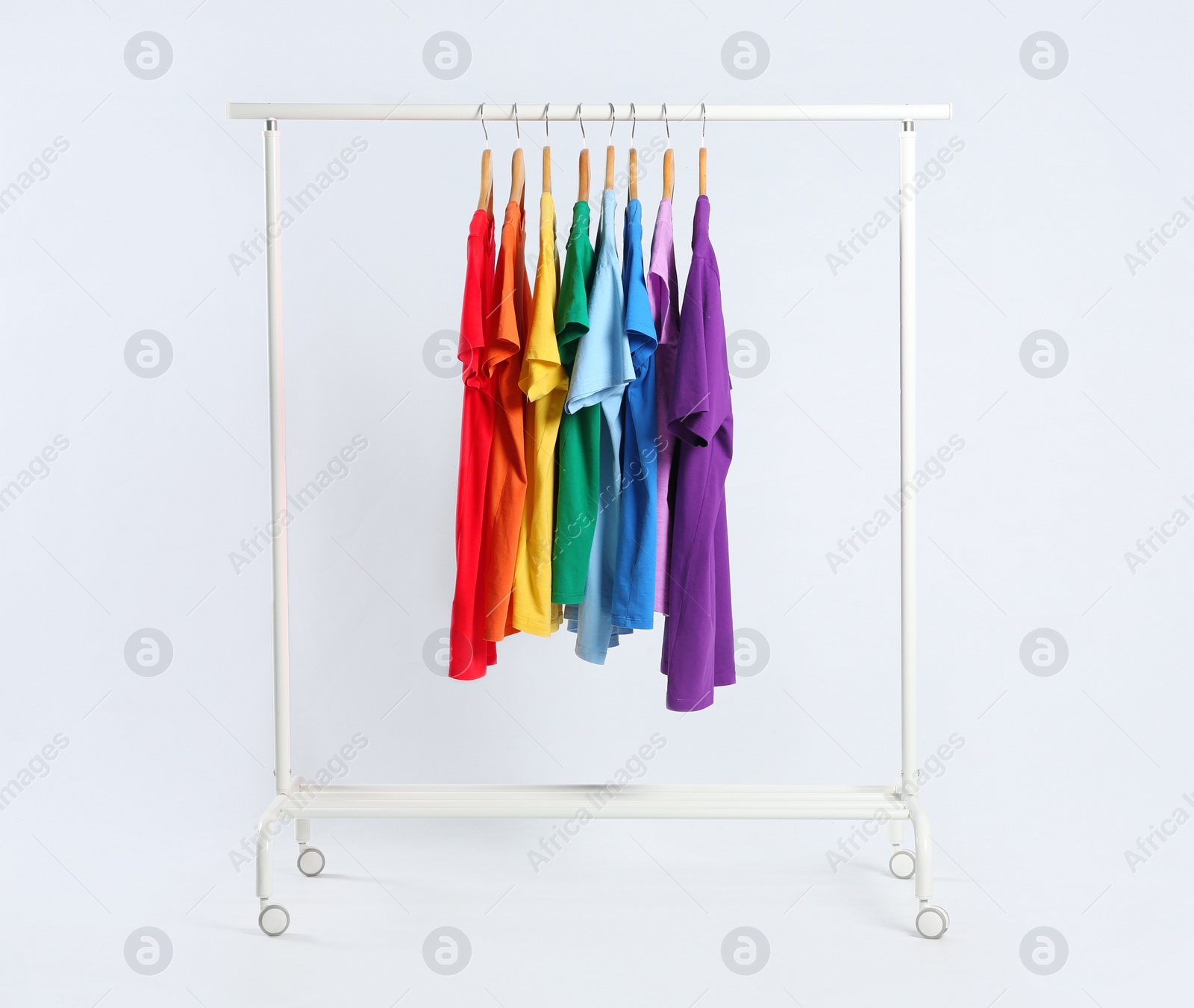 Photo of Colorful clothes hanging on rack against white background