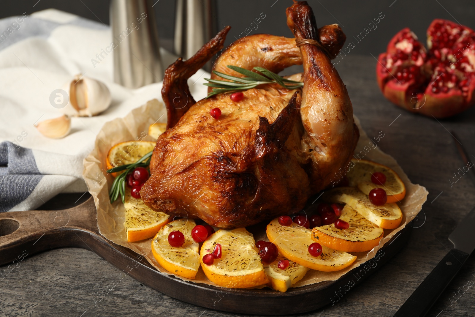 Photo of Baked chicken with orange slices on grey table