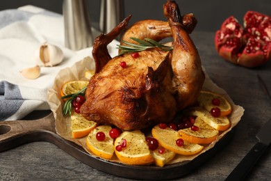 Photo of Baked chicken with orange slices on grey table