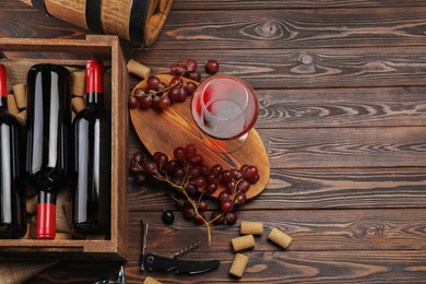 Photo of Winemaking. Flat lay composition with tasty wine and barrel on wooden table, space for text