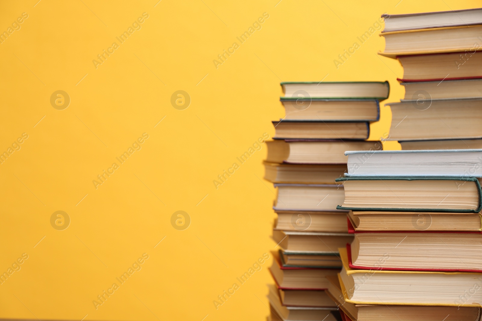 Photo of Many hardcover books on orange background, space for text. Library material