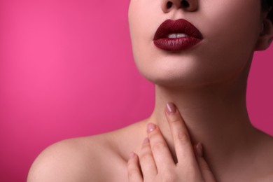 Photo of Closeup view of woman with beautiful full lips on pink background, space for text