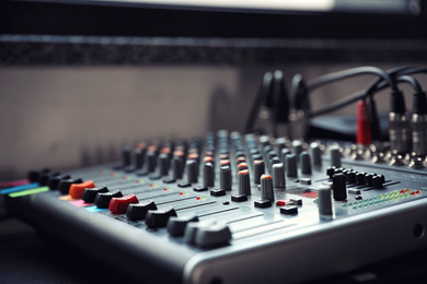 Photo of Modern audio mixing console, closeup. Music equipment