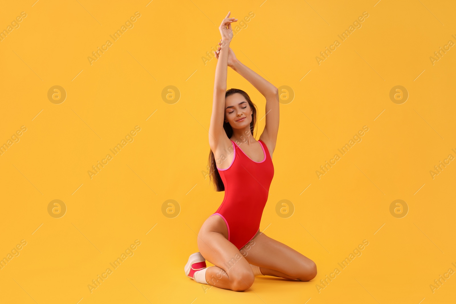 Photo of Young woman in stylish swimsuit on yellow background