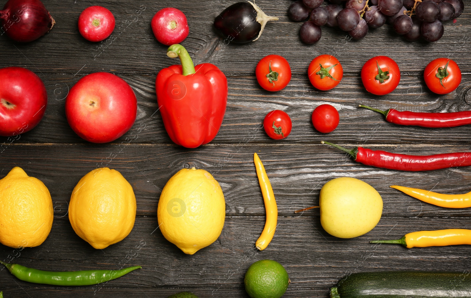 Photo of Rainbow collection of ripe fruits and vegetables on wooden background, top view