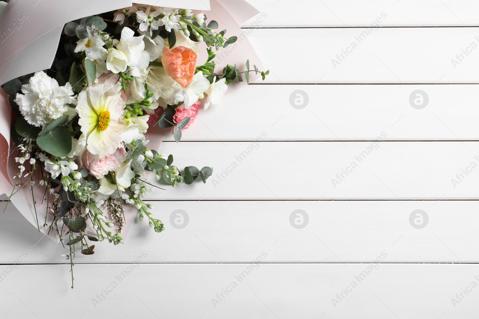 Photo of Bouquet of beautiful flowers on white wooden table, top view. Space for text