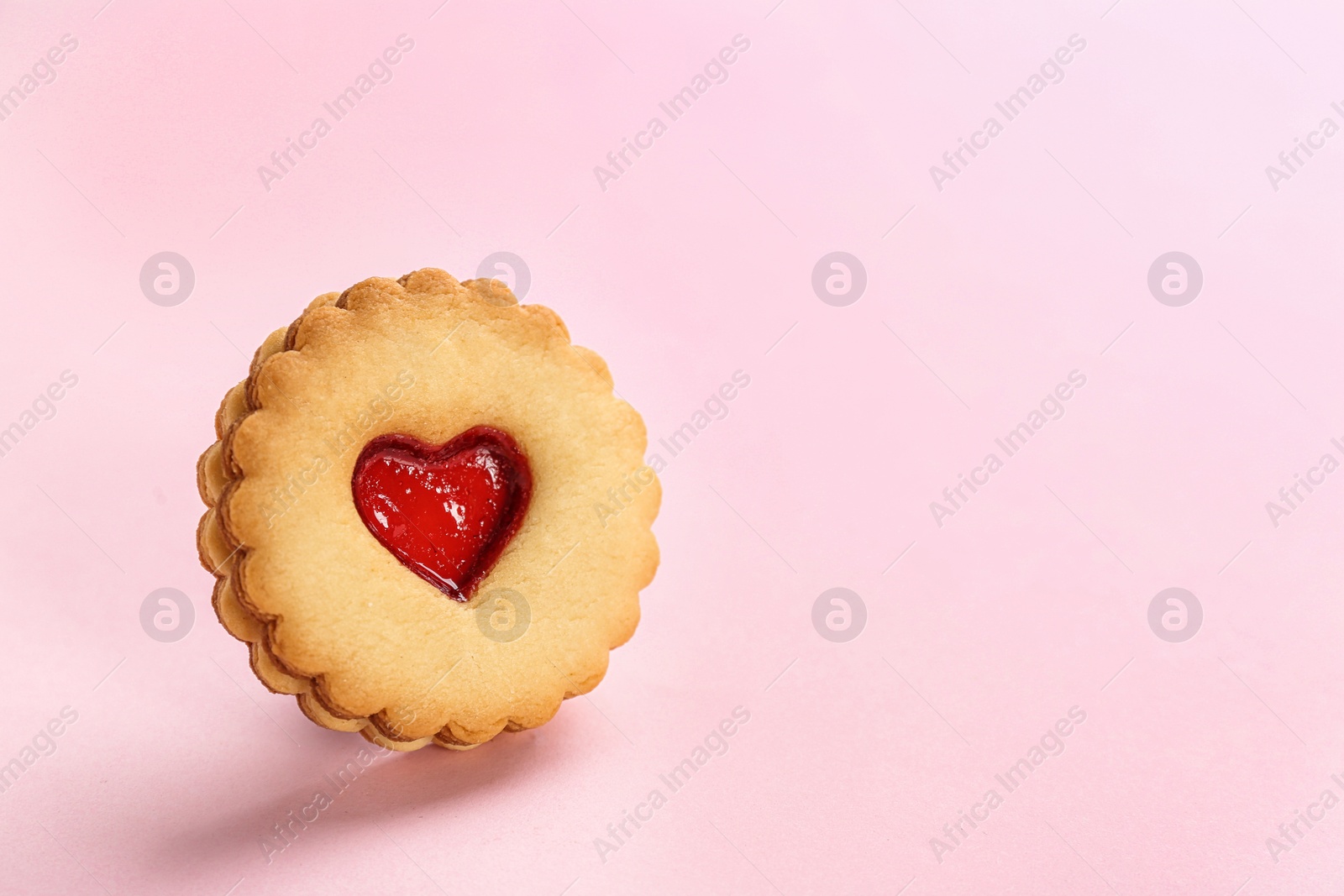 Photo of Traditional Christmas Linzer cookie with sweet jam on color background