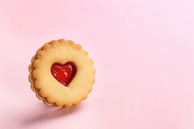 Traditional Christmas Linzer cookie with sweet jam on color background