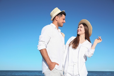 Lovely couple wearing hats together on beach