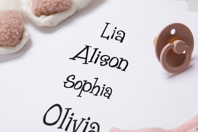 Photo of List of baby names and child's accessories, closeup
