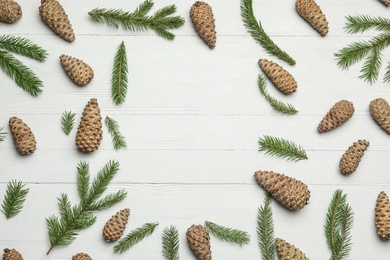 Photo of Flat lay composition with pinecones on white wooden background, space for text