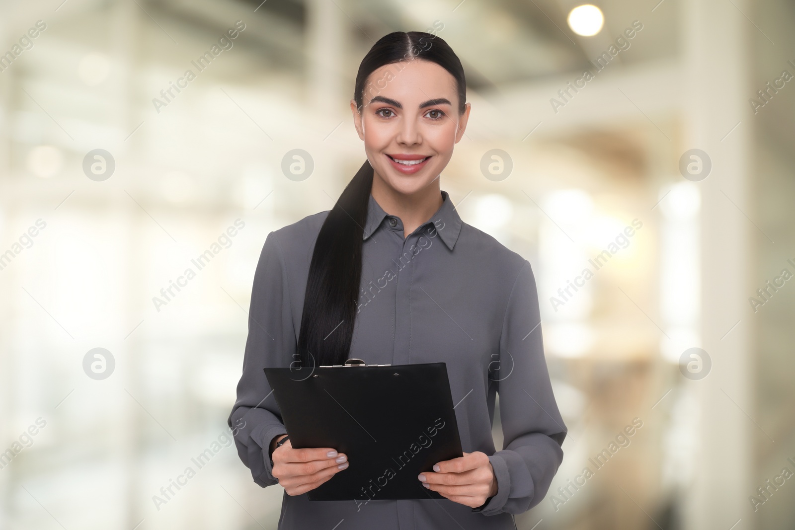 Image of Lawyer, consultant, business owner. Confident woman with clipboard smiling indoors