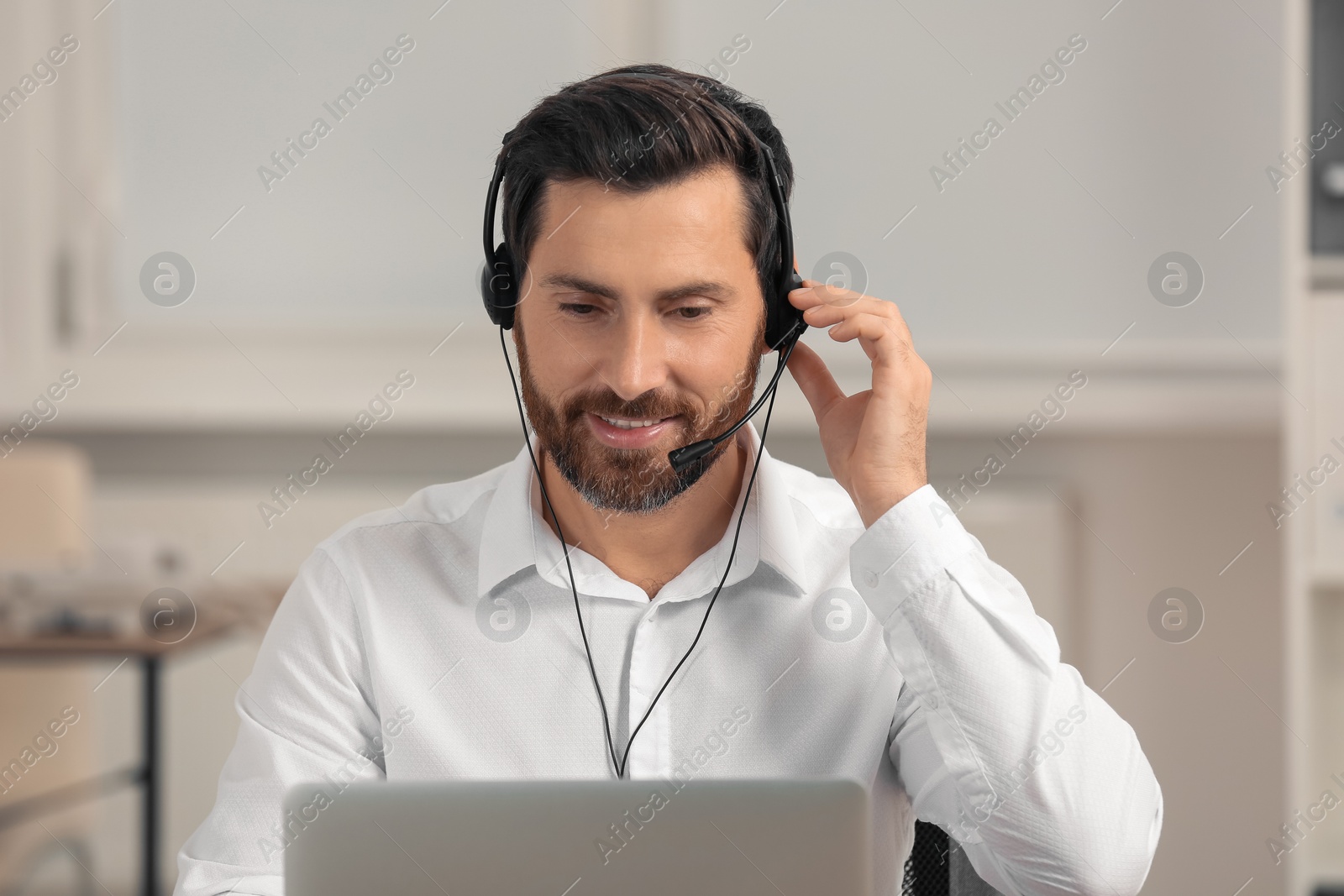 Photo of Hotline operator with headset working in office