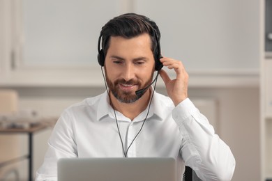 Photo of Hotline operator with headset working in office