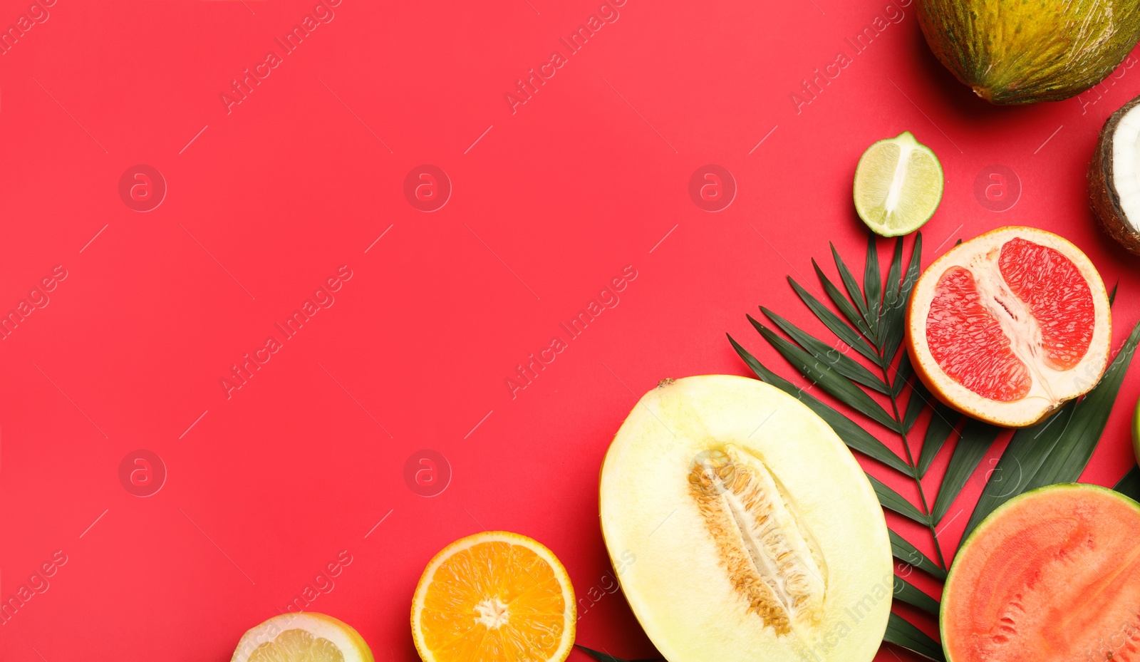 Photo of Flat lay composition with tasty melon and fresh tropical fruits on red background, space for text