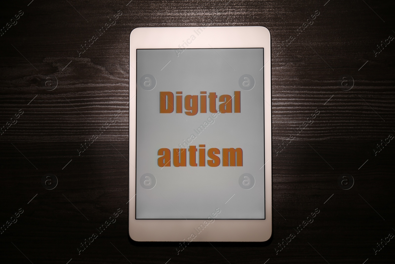 Photo of Tablet with phrase Digital Autism on wooden table, top view. Addictive behavior