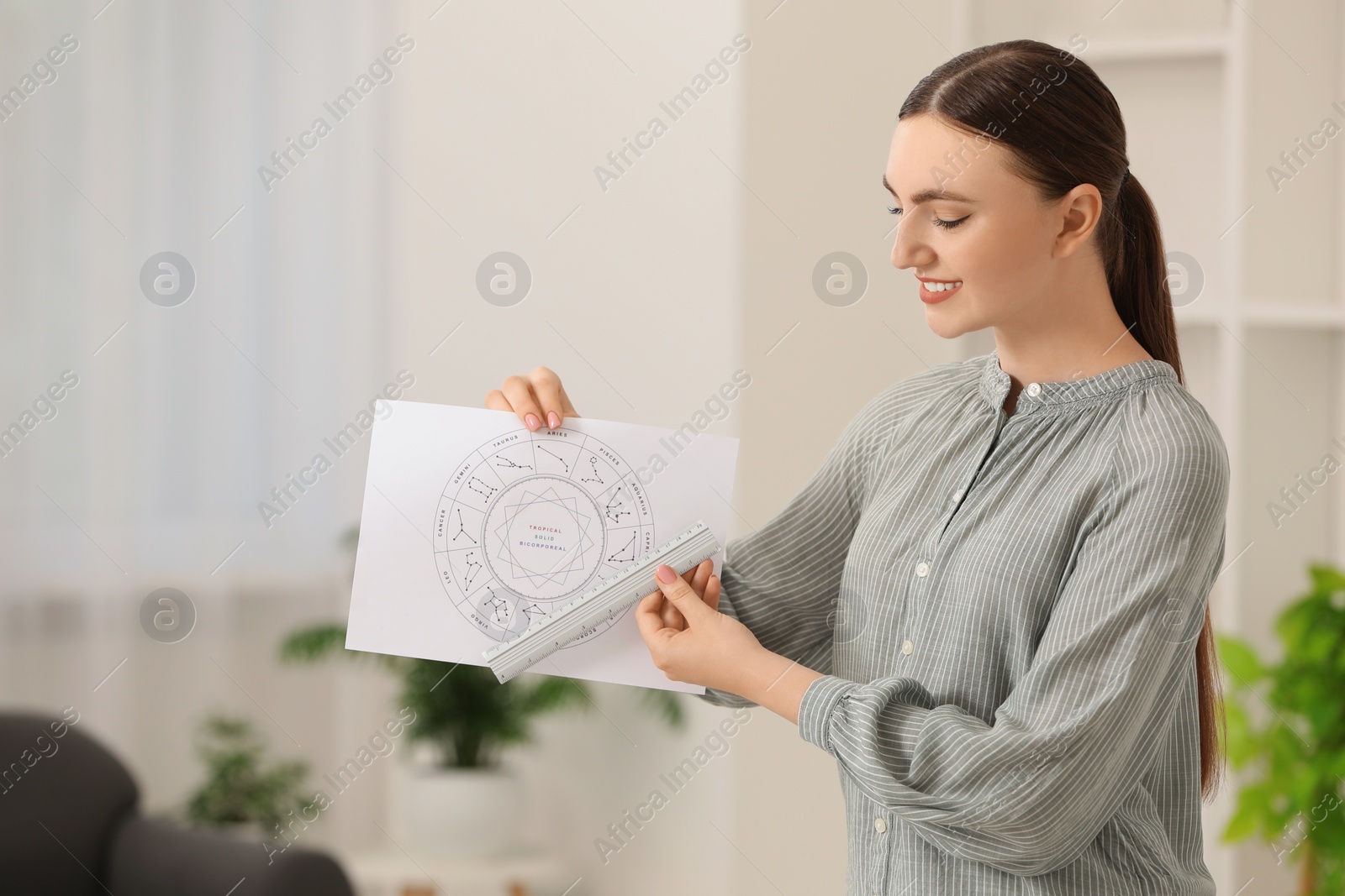 Photo of Astrologer using zodiac wheel for fate forecast indoors. Fortune telling