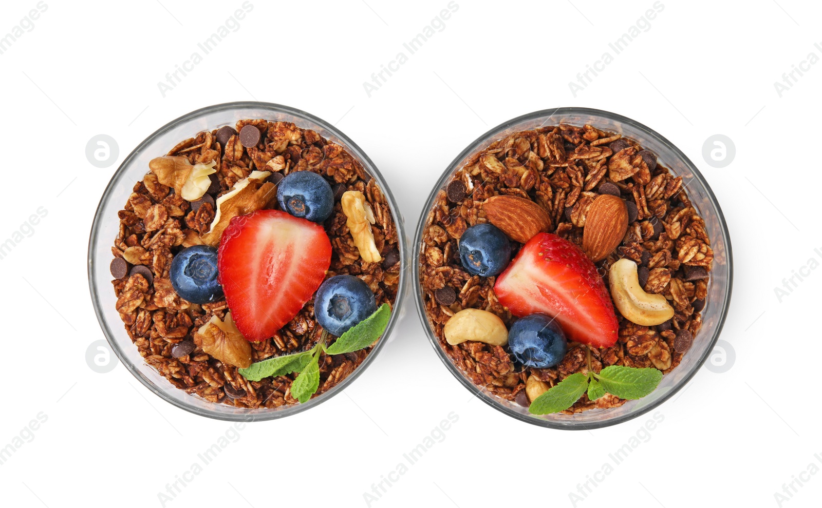 Photo of Tasty granola with berries and nuts in glasses isolated on white, top view