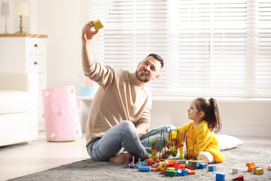 Photo of Father playing with his child at home