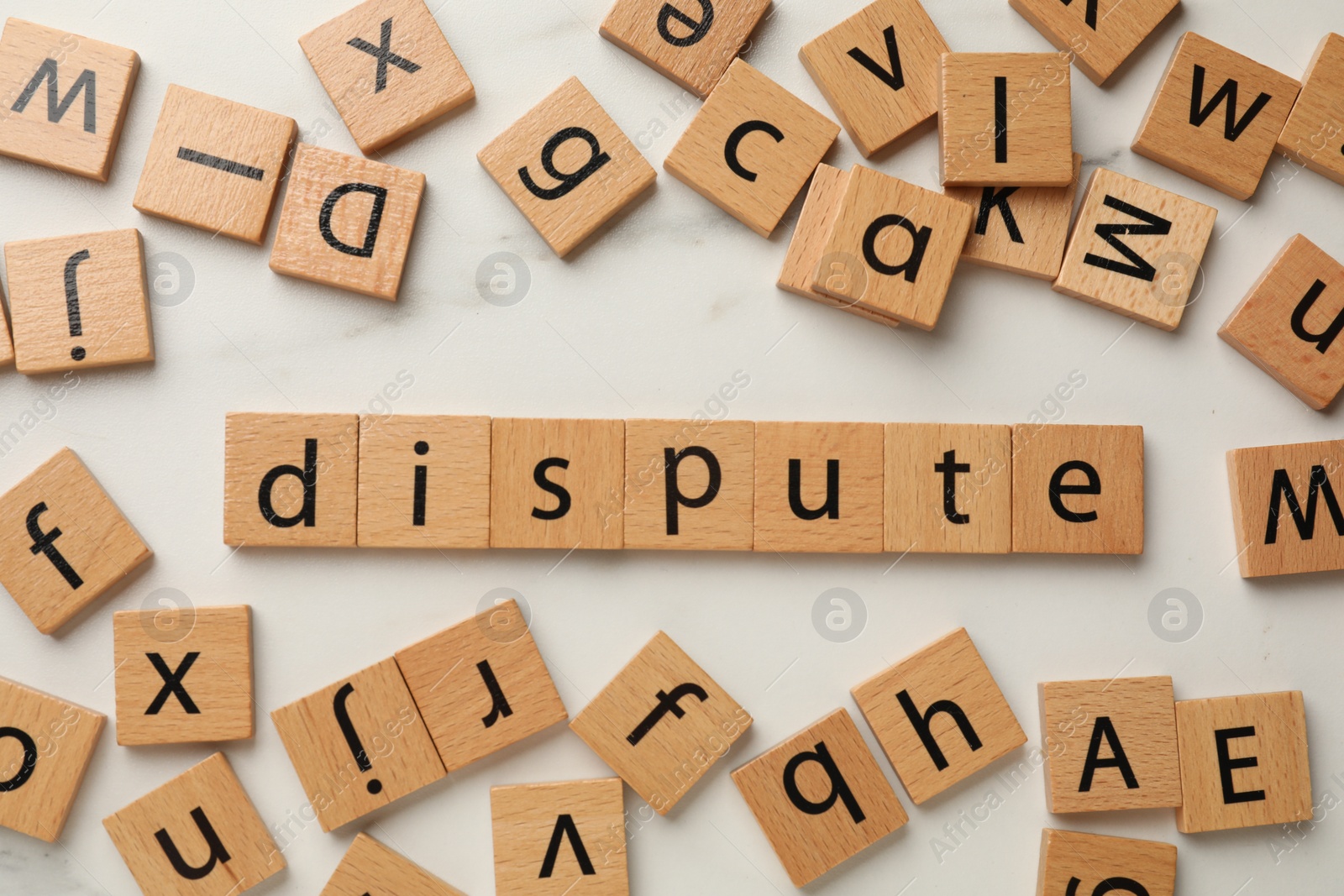 Photo of Squares with word Dispute on white marble table, flat lay