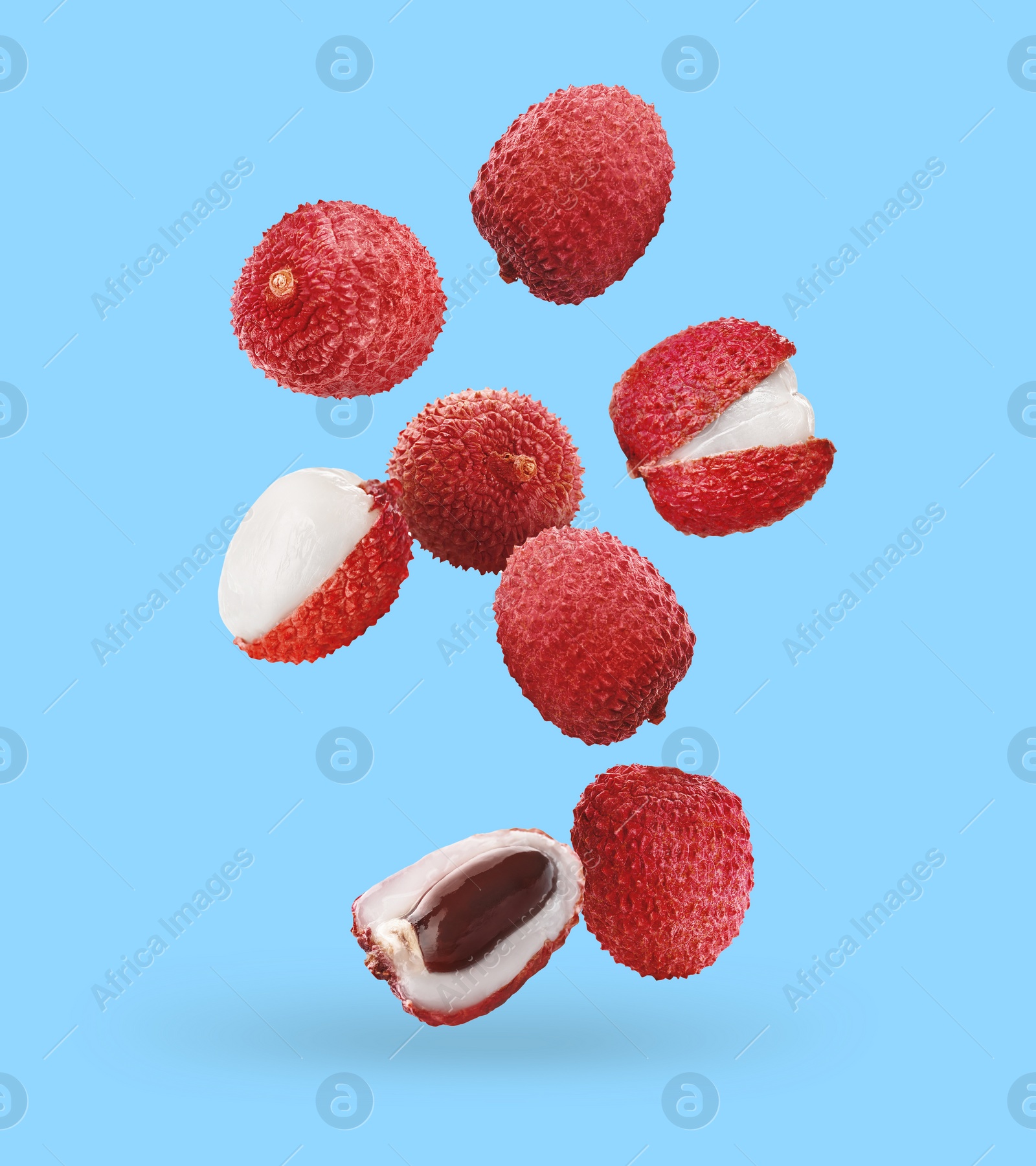 Image of Fresh lychees falling on light blue background