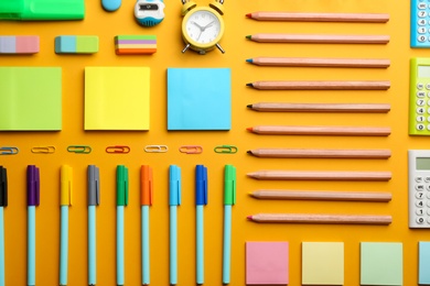 Photo of Flat lay composition with school stationery on orange background. Back to school