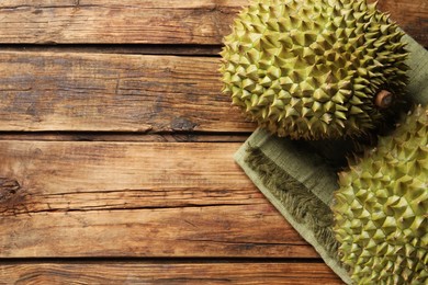 Photo of Ripe durians on wooden table, flat lay. Space for text