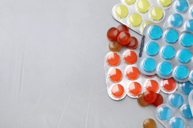 Photo of Colorful cough drops on grey background, flat lay. Space for text