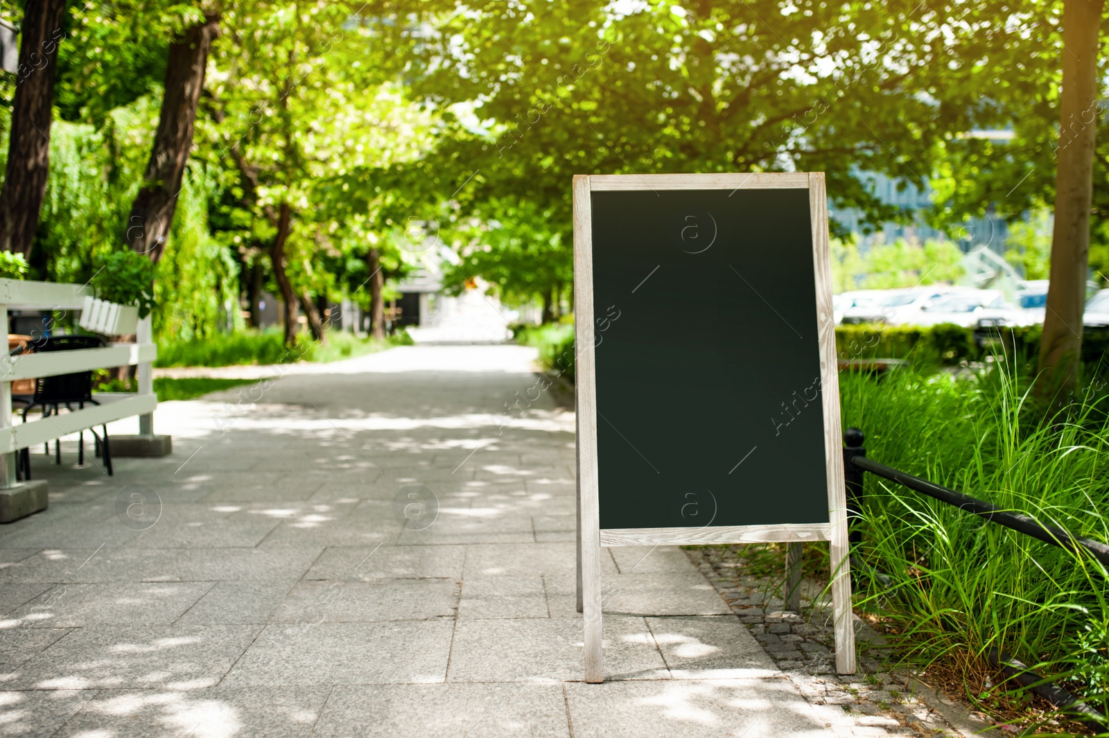 Photo of Blank advertising A-board outdoors. Mockup for design