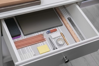 Photo of Office supplies in open desk drawer, closeup