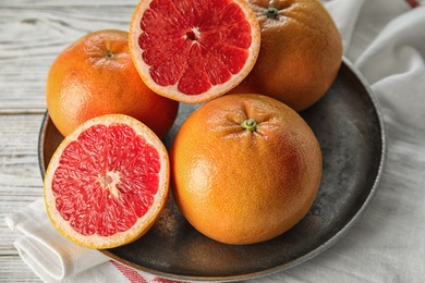 Photo of Plate of fresh tasty grapefruits on table