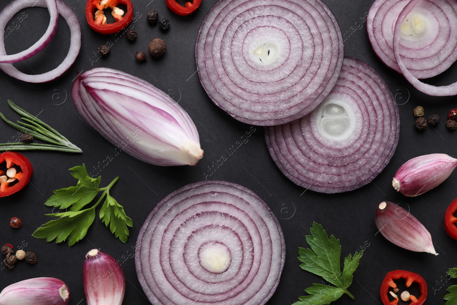 Photo of Flat lay composition with cut onion and spices on black background