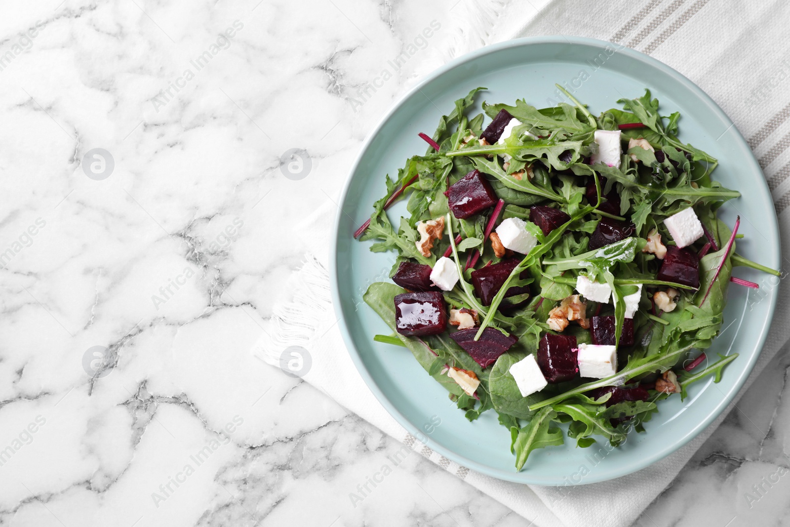 Photo of Fresh delicious beet salad on white marble table, top view. Space for text