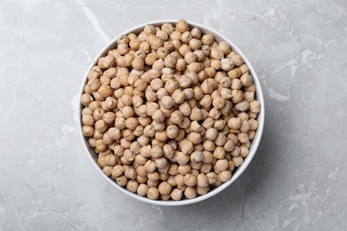 Photo of Chickpeas in bowl on light grey table, top view