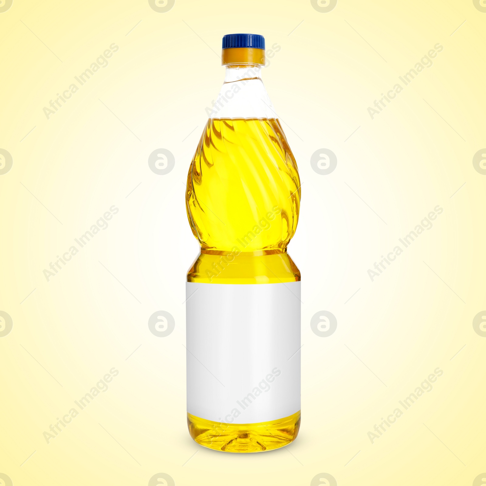 Image of Cooking oil in plastic bottle with empty label on light yellow background. Mockup for design