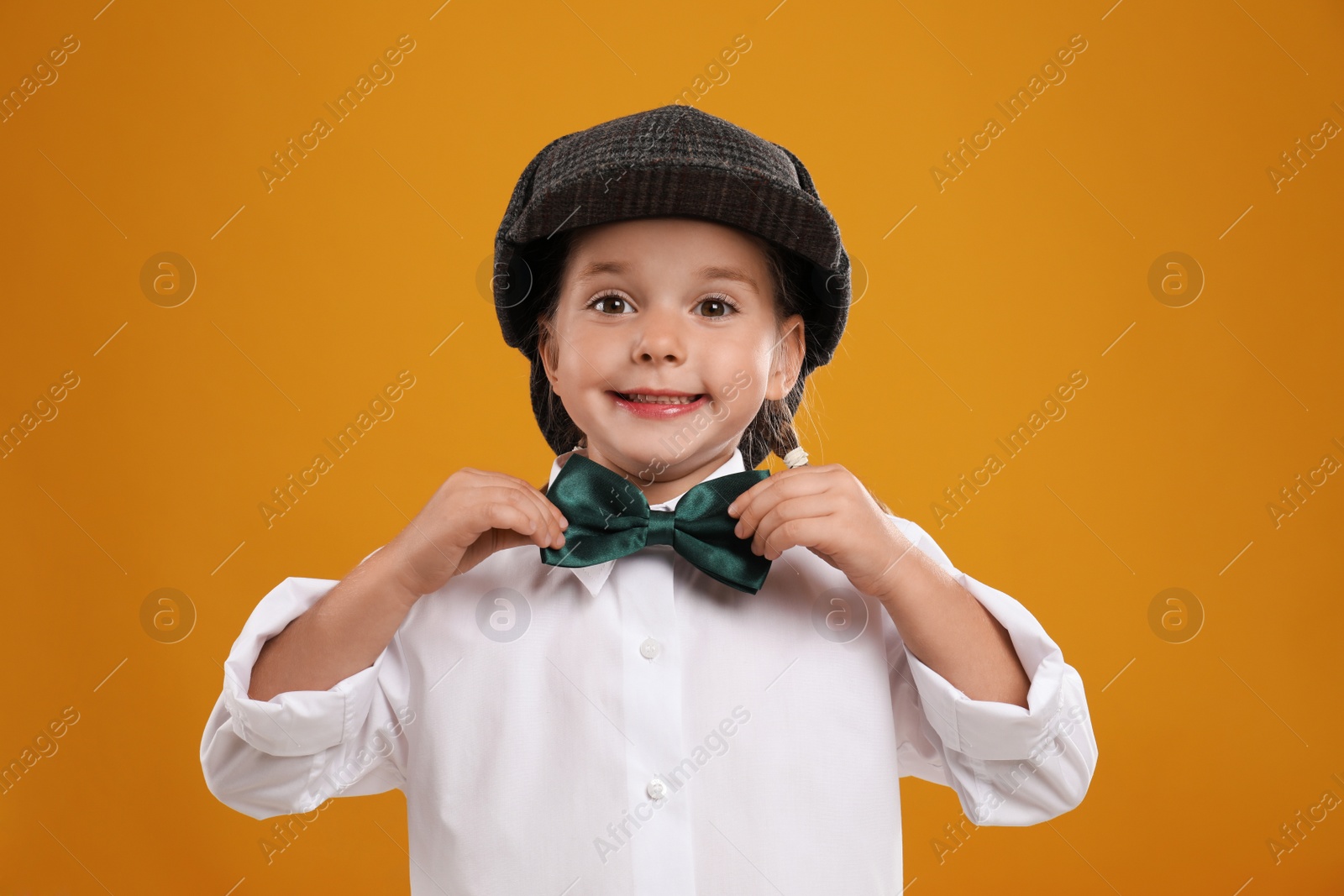 Photo of Cute little detective in hat on yellow background